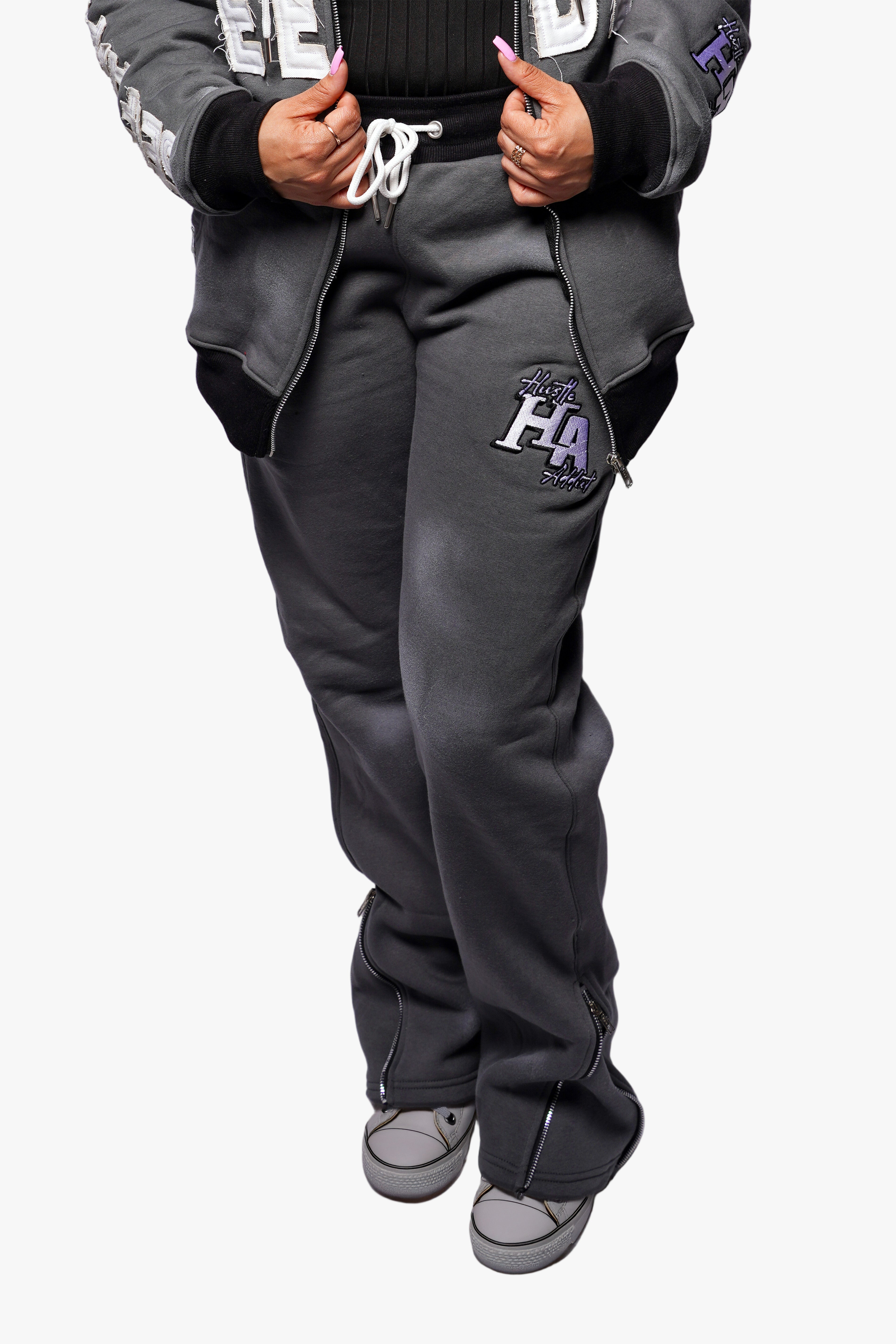 Person wearing gray sweatpants and hoodie on a plain background